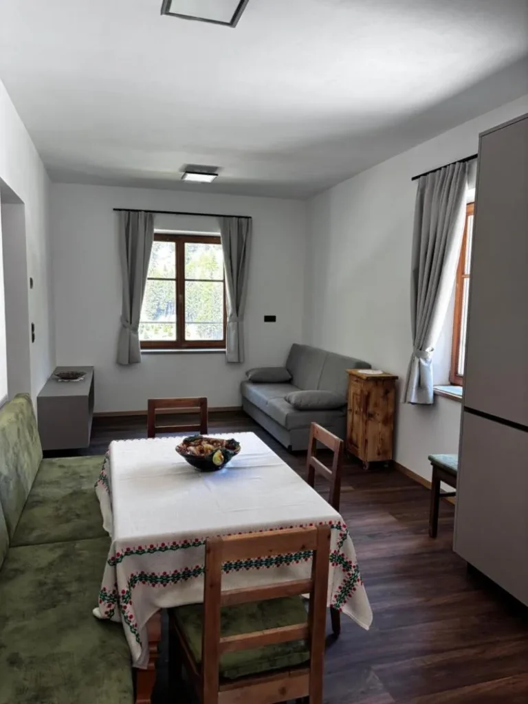 Wohnzimmer mit kleiner Couch und kleinem Esszimmer